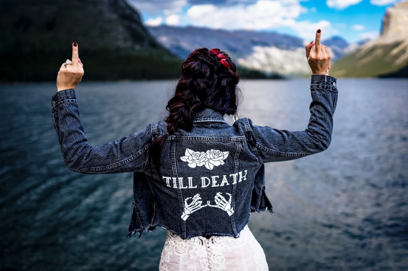 Bride facing the lake and showing her middle finger.