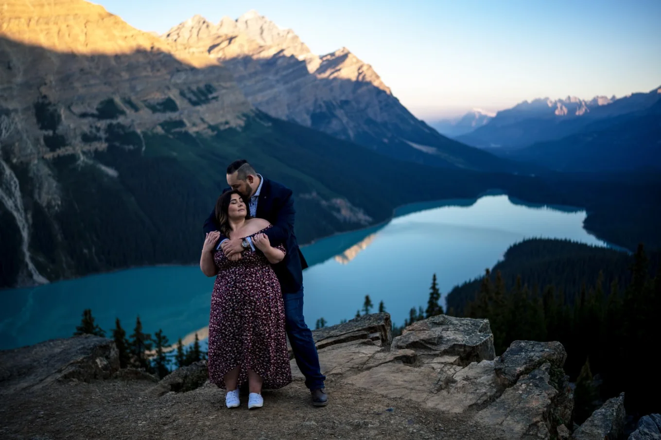 Engaged couple in love standing in a hug at amazing Peyto Lake in the Canadian Rockies.