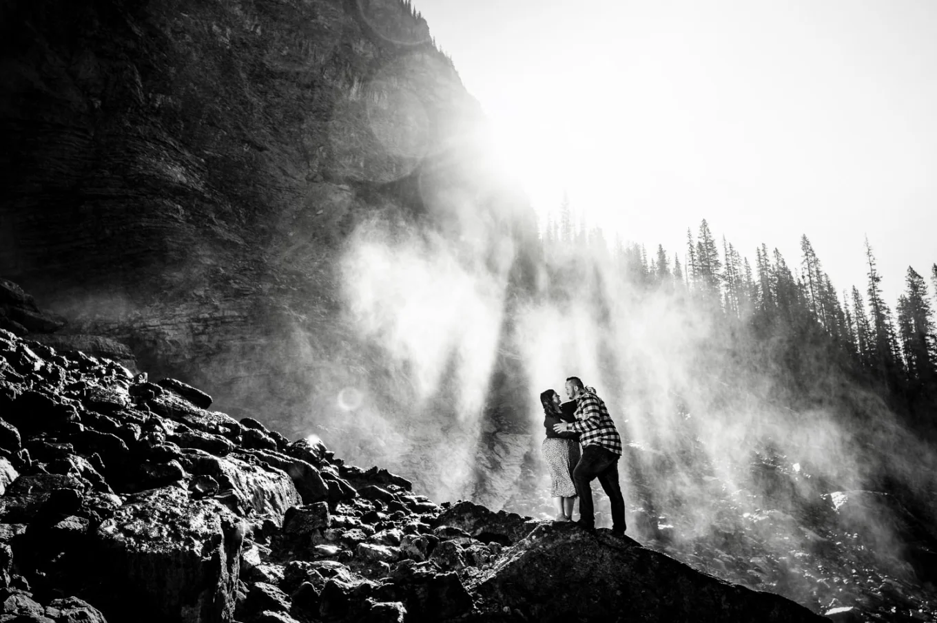 Engaged couple embraced in the sunlight during engagement session in Banff.