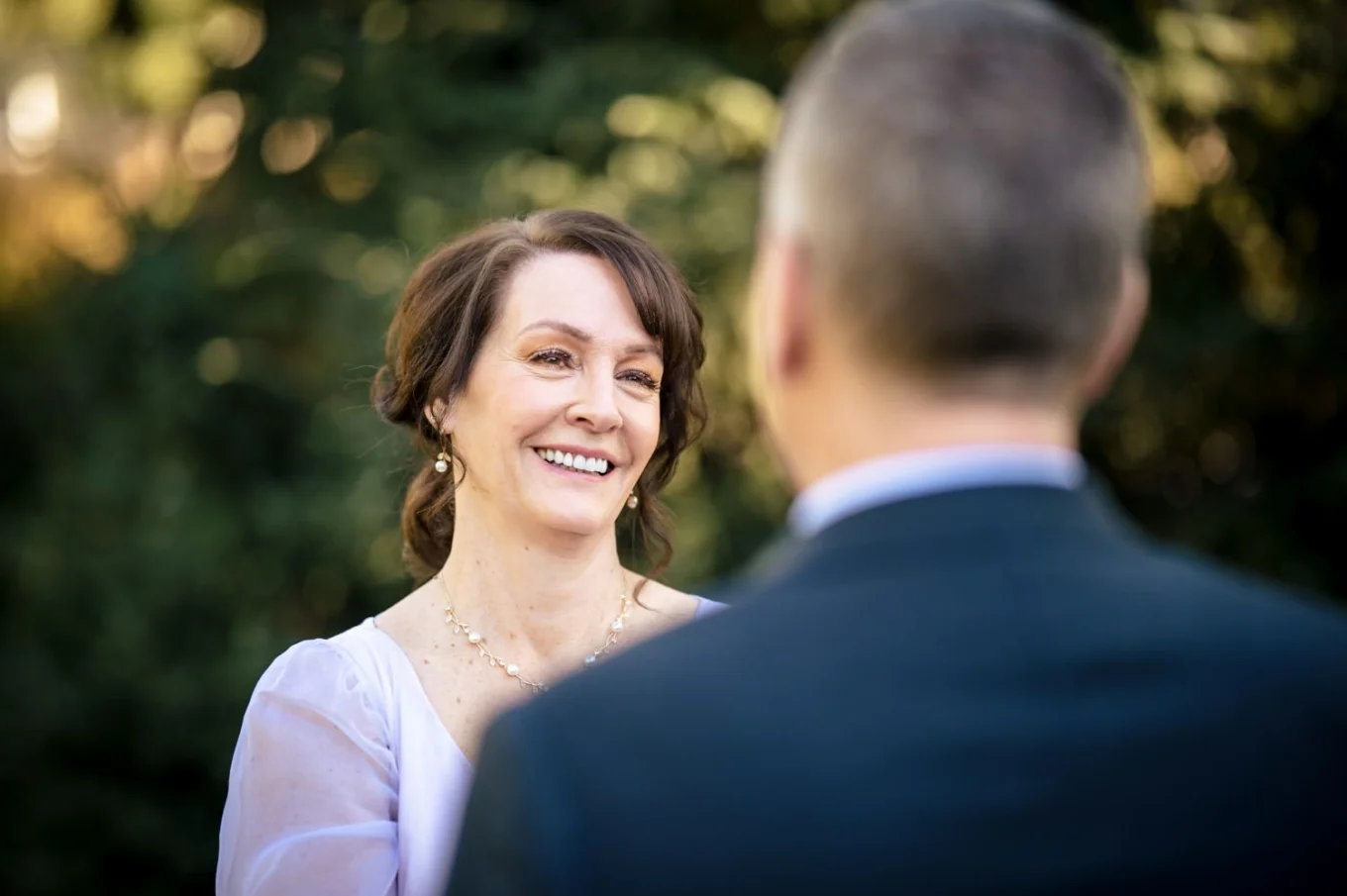 charming bride looks with love in her eyes at her new husband.