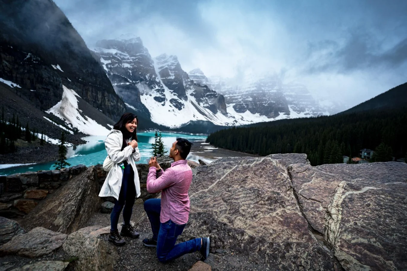 Man goers down the knee with the engagement ring and propose at Moraine Lake. Moment captured by the best Calgary Wedding Photographers.