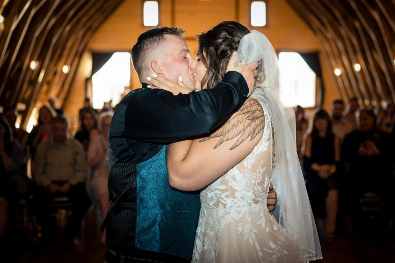 First kiss of bride and groom in rustic shed. Photo taken by talented Calgary Wedding Photographer.