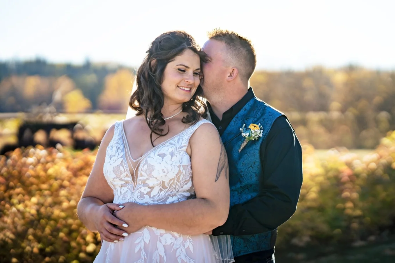 Groom whispers a secret into the bride's ear. Fall after-wedding session taken by Calgary Wedding Photographer