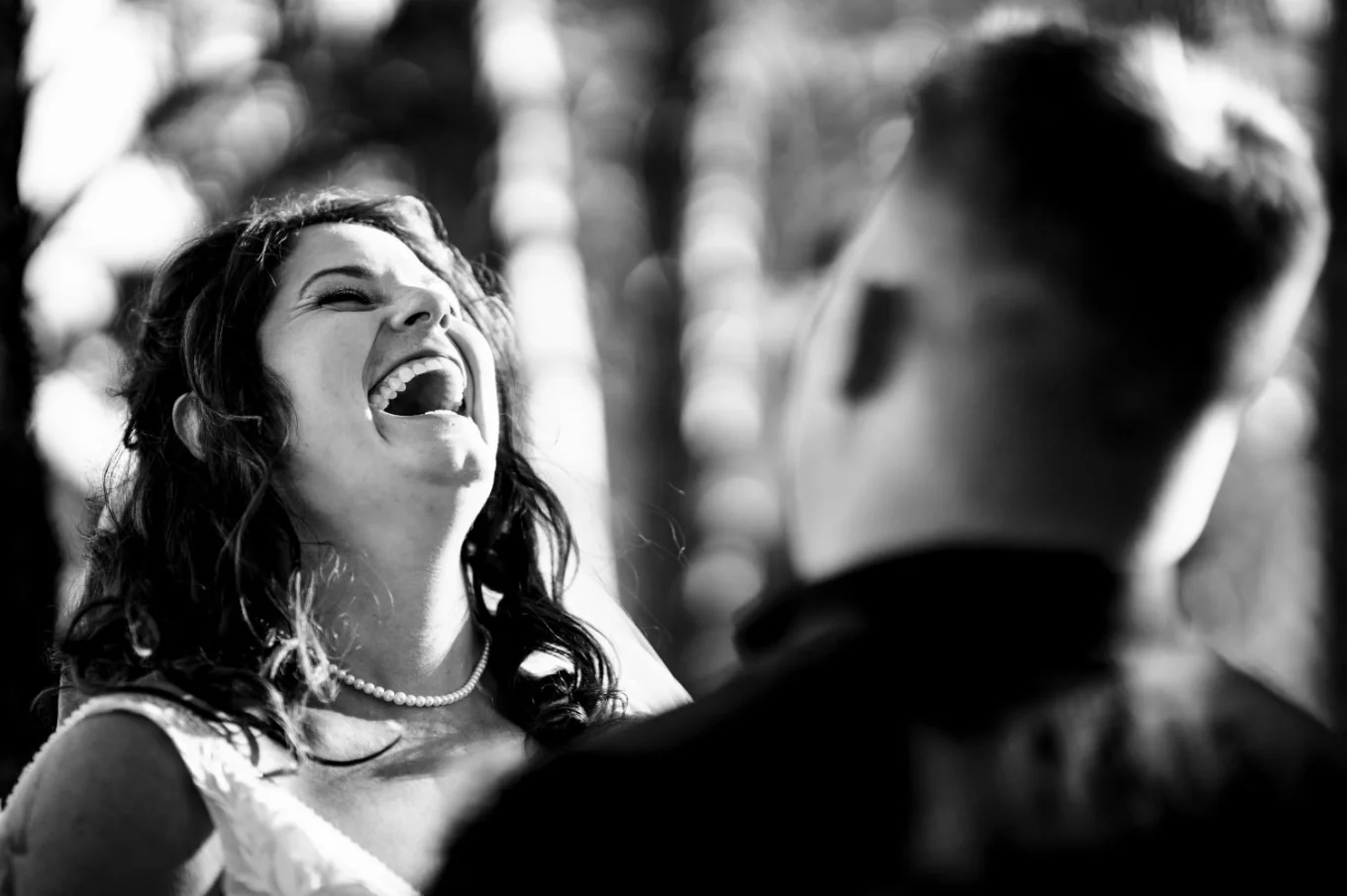 Funny moment captured by Banff Wedding Photographer of the bride laughing loud at the groom standing in front of her.