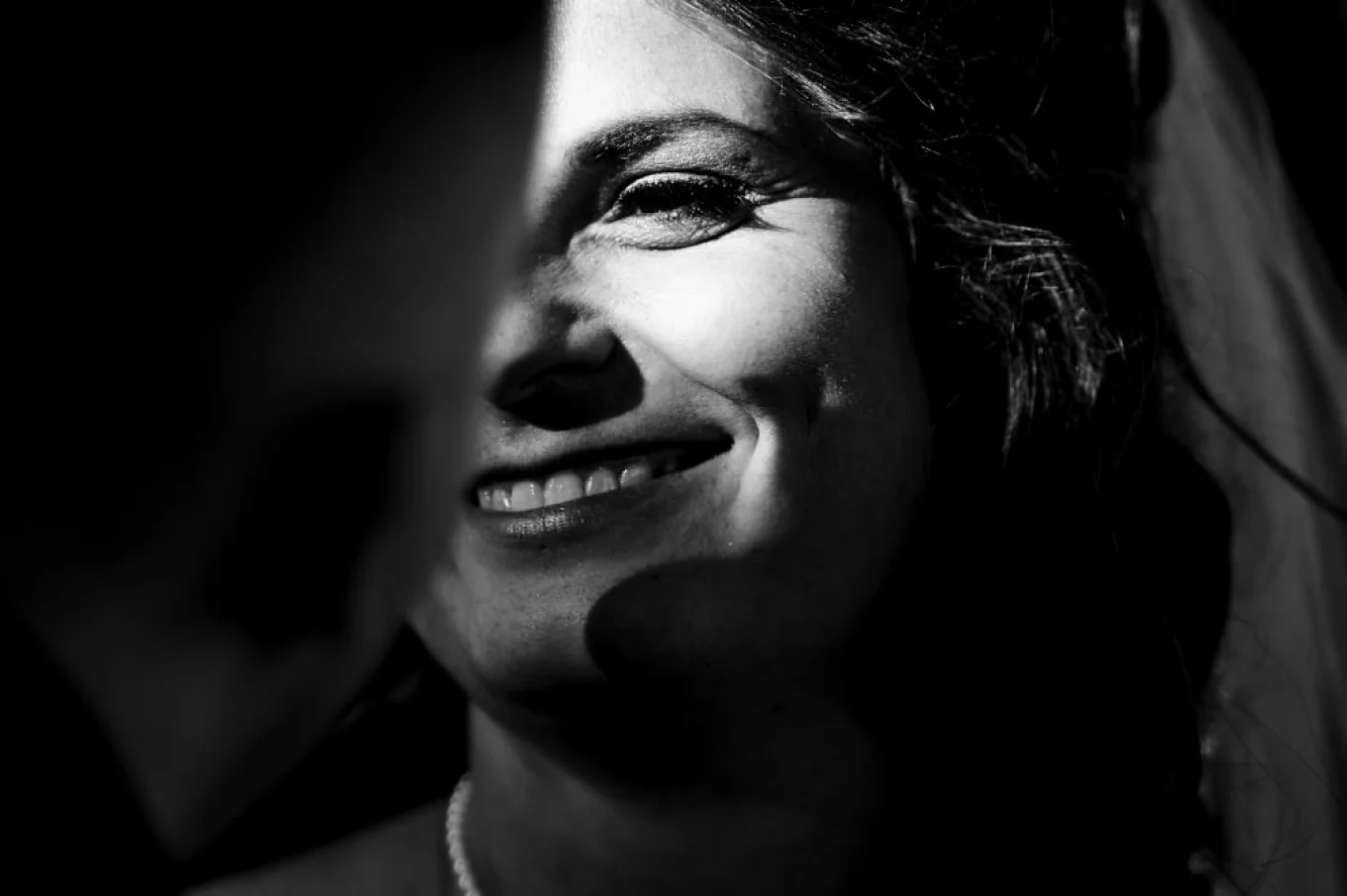 Calgary Wedding Photography in black and white. Bride look at the groom and her eye is lighted by sun.