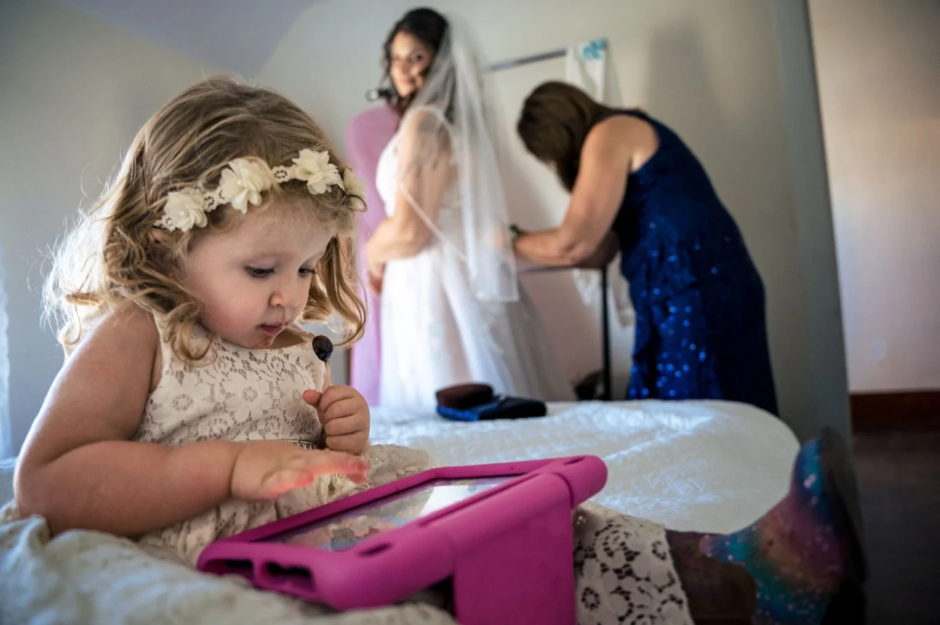 Flower-girl plays games on IPad while the bride is getting ready to attend Calgary Wedding Ceremony.