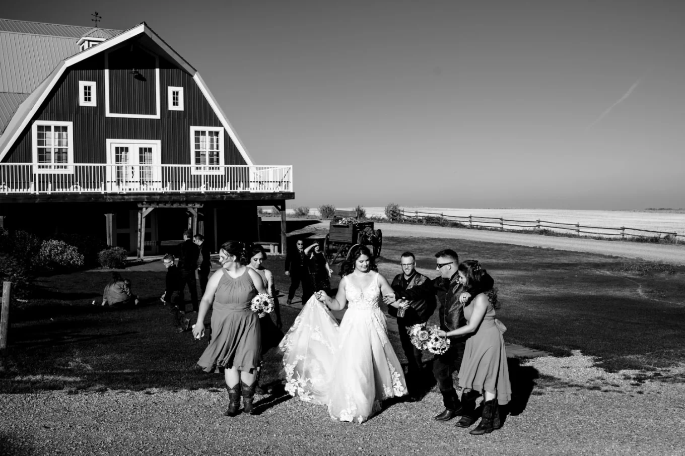 Wedding Party walking in front of the venue building in Calgary They talk with each other and have fun. Photograph in black and white taken by Banff Wedding Photographer. .
