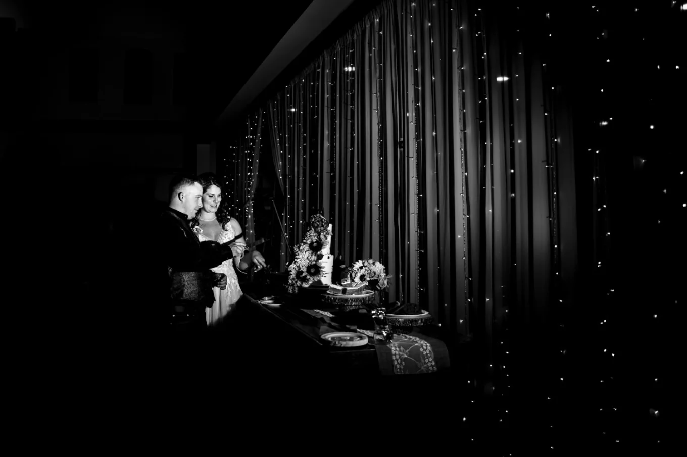 Calgary Wedding Photography in black and white. Bride and groom cutting a wedding cake.
