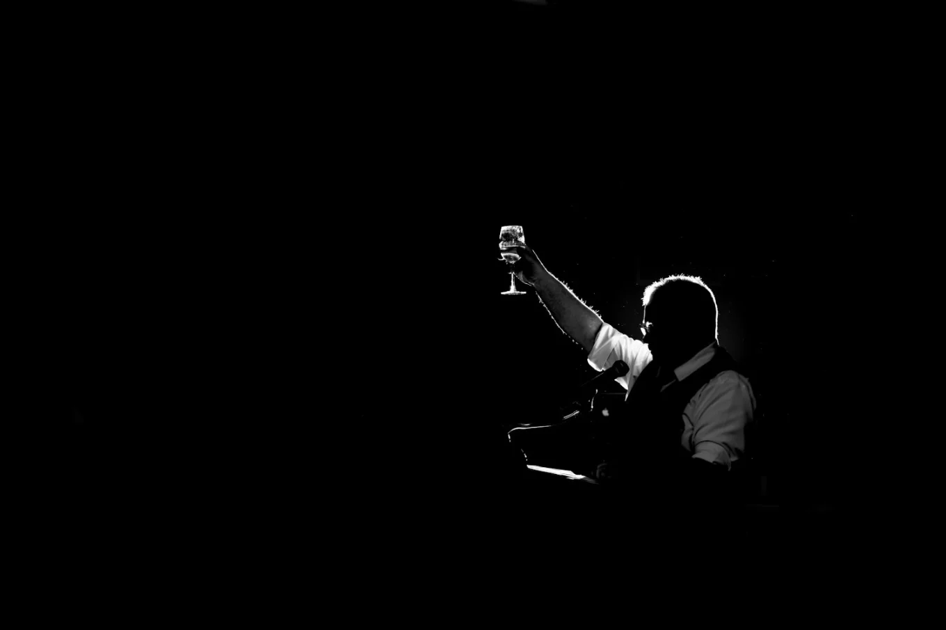 Father of the bride gives a speech with a glass of champagne in his hands.