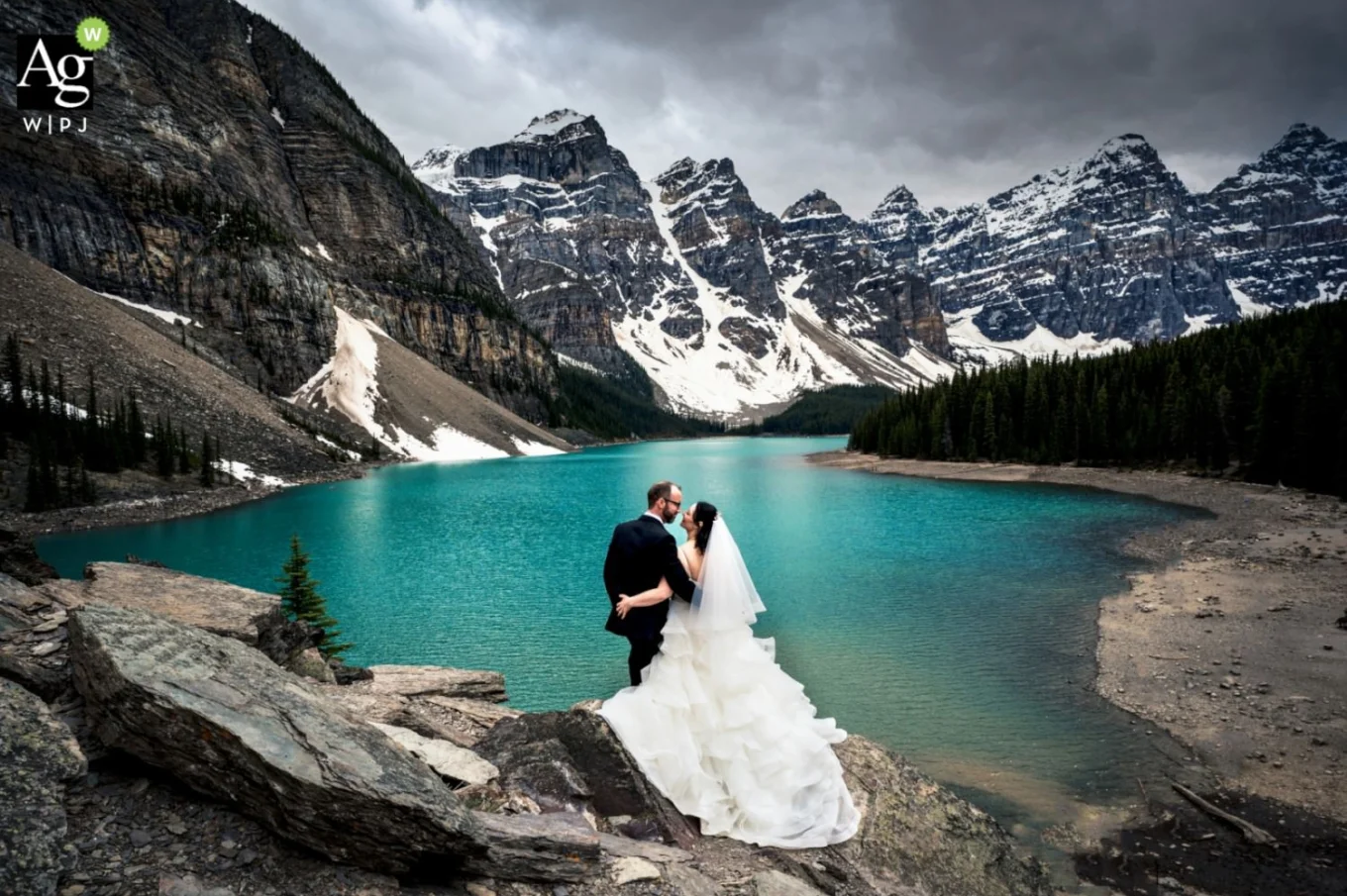 At Moraine Lake Bride and Groom Celebrate Their love and admire the beauty of the turquoise lake in the Canadian Mountains