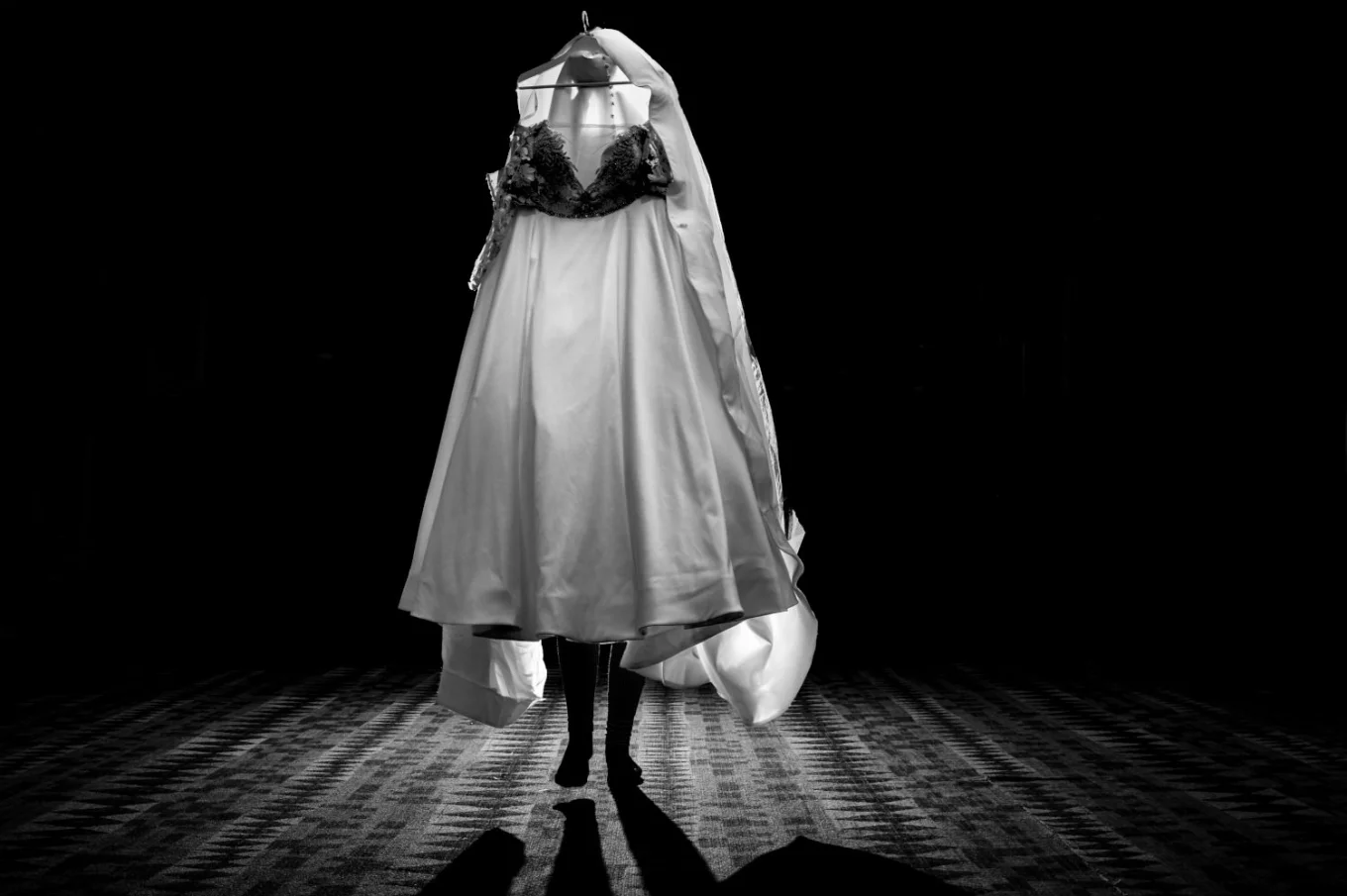 Bride carries a wedding dress in Banff. Photograph in black and white taken by talented Banff Wedding Photographer.