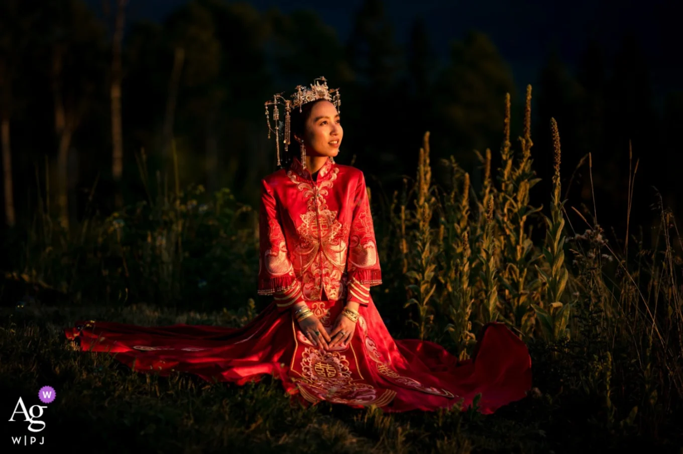 Bride wearing traditional Chinese wedding dress sitting on the ground
