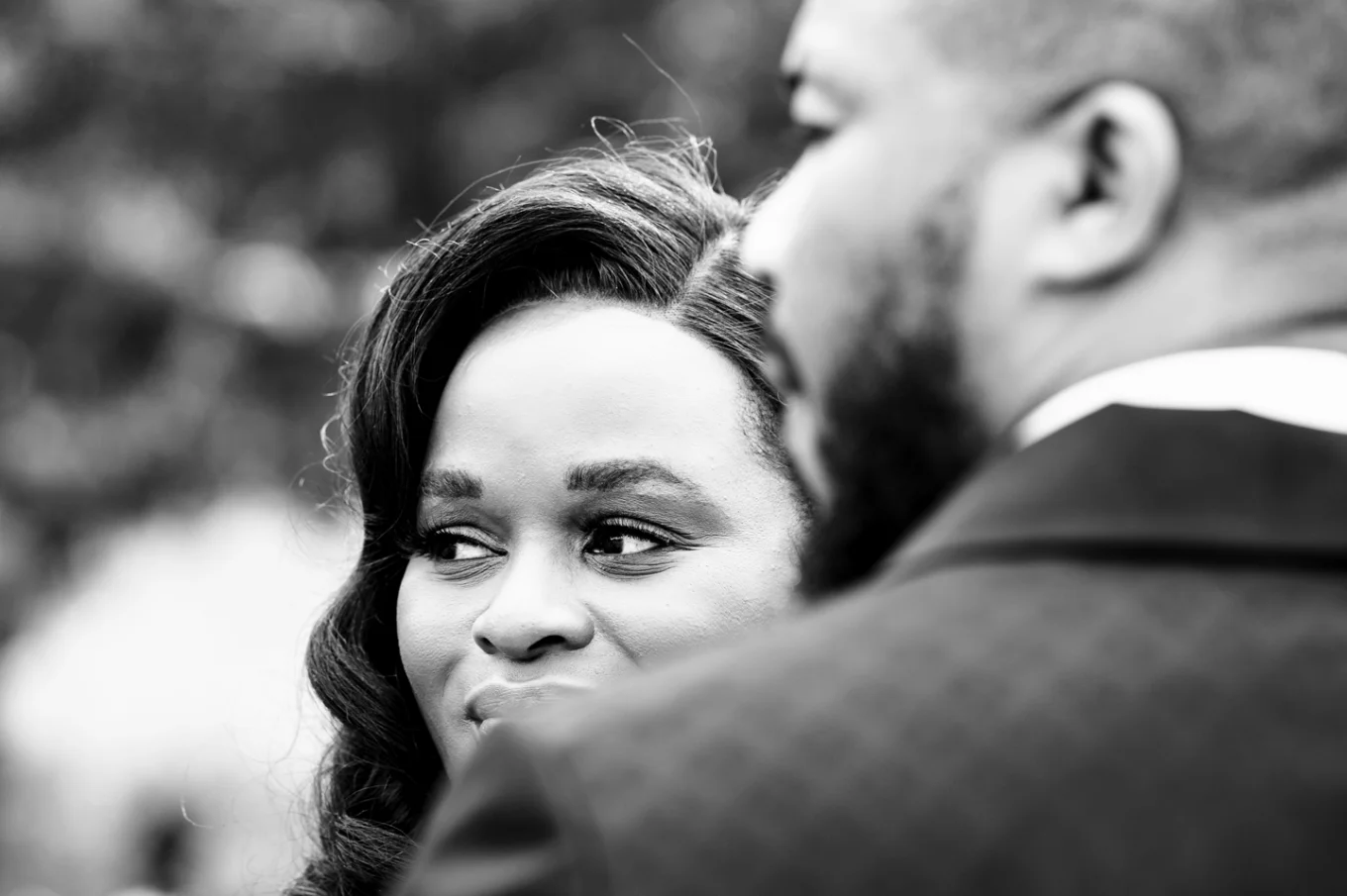 Bride and groom faces looking away in black and white.