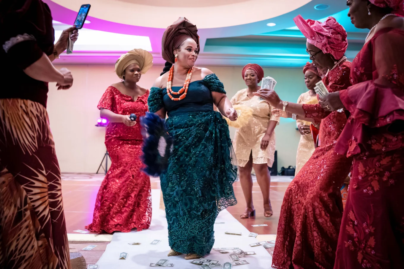 Entrance of the bride at the Nigerian Wedding in Calgary. She wears a green traditional attire. Her Familly around her dancing with her.