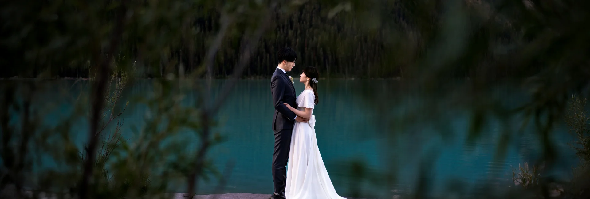 Newlyweds look at each other during wedding portrait session in Lake Louise