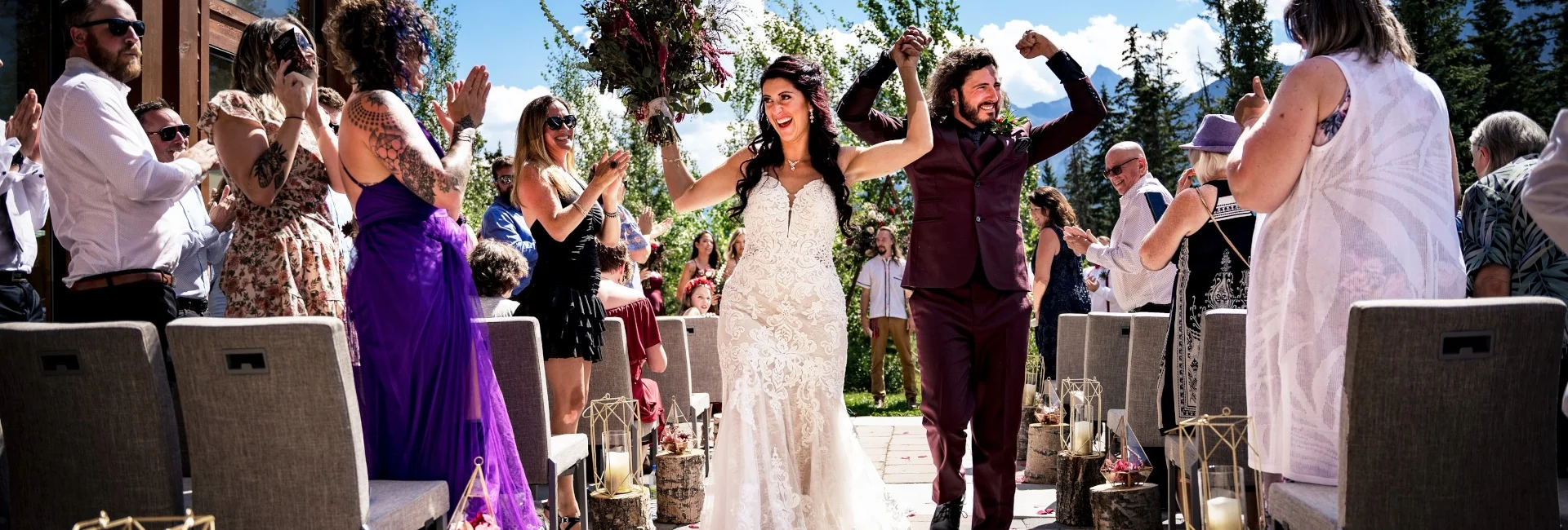 Happy walk of married couple with hands up after Banff Wedding Ceremony
