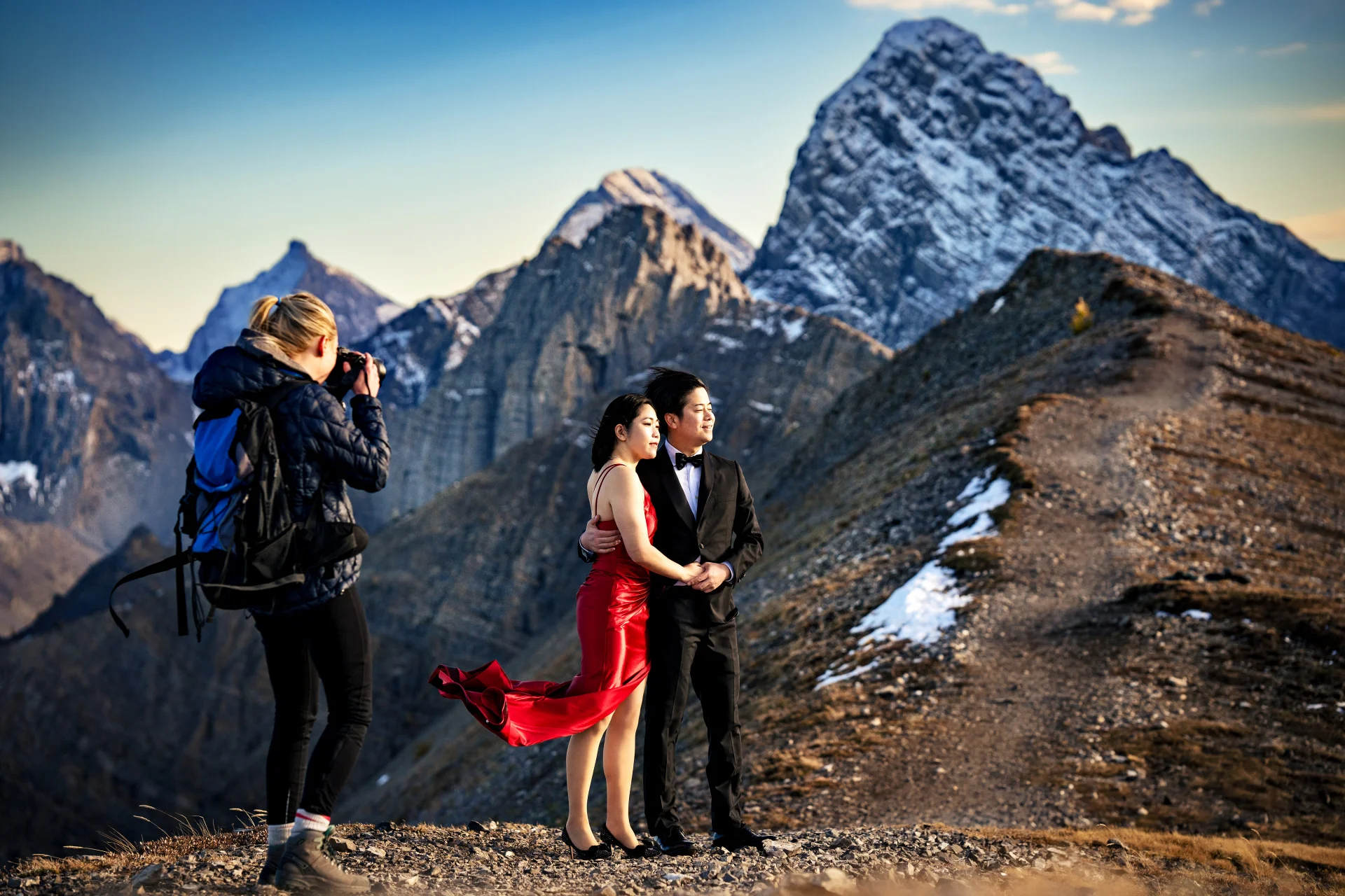 Photographers takes photo of couple at the top of the mountain