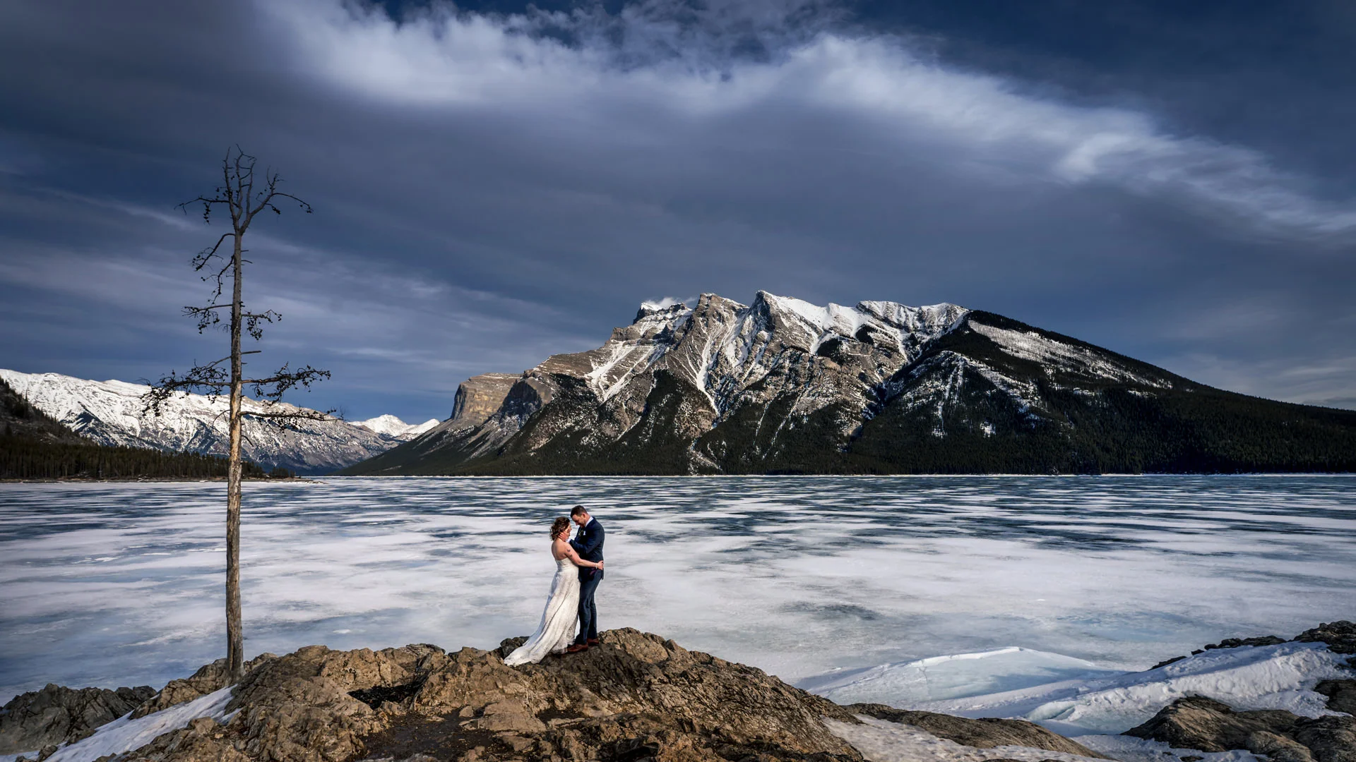Newlyweds hug during after wedding session in Banff