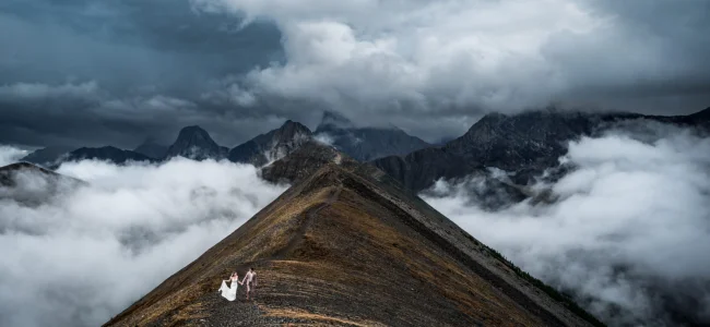 Bride and groom walk on the ridge