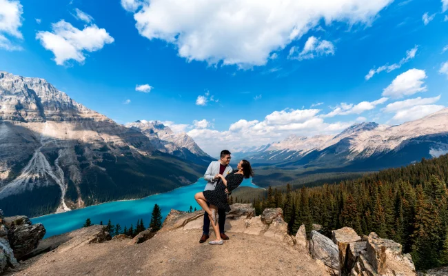 Engaged couple in love dance at Payto Lake against Rocky Mountains.