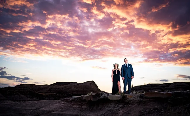 Engaged couple stand on the horseshoe Canyon . Above their heads stunning, colourful clouds.