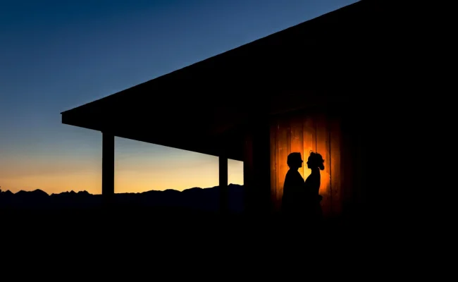 silhouette married couple looking at each other. against reception building in Banff