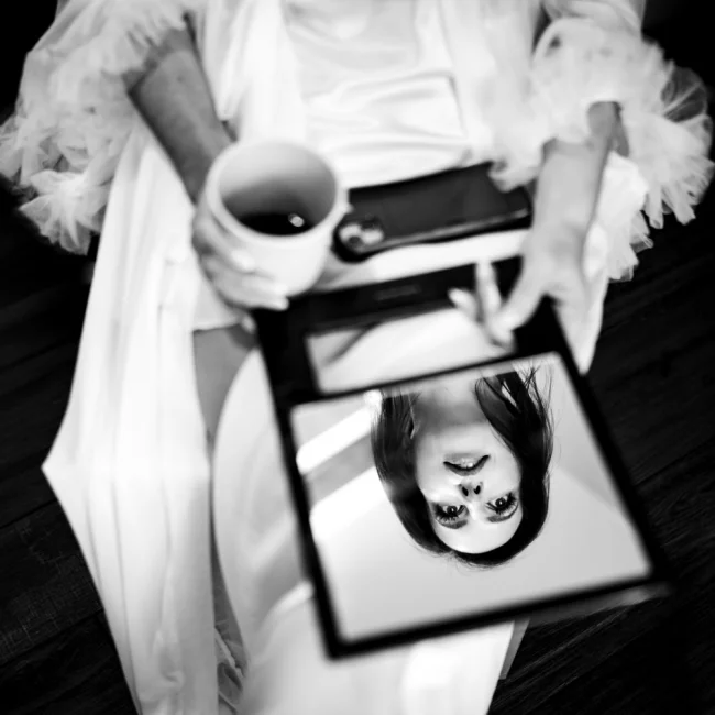 Camore wedding photography of the bride sitting on the chair with her face reflected in the small mirror