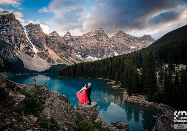 Award Winning photography at Moraine Lake of the couple standing on the rock against Rocky Mountains
