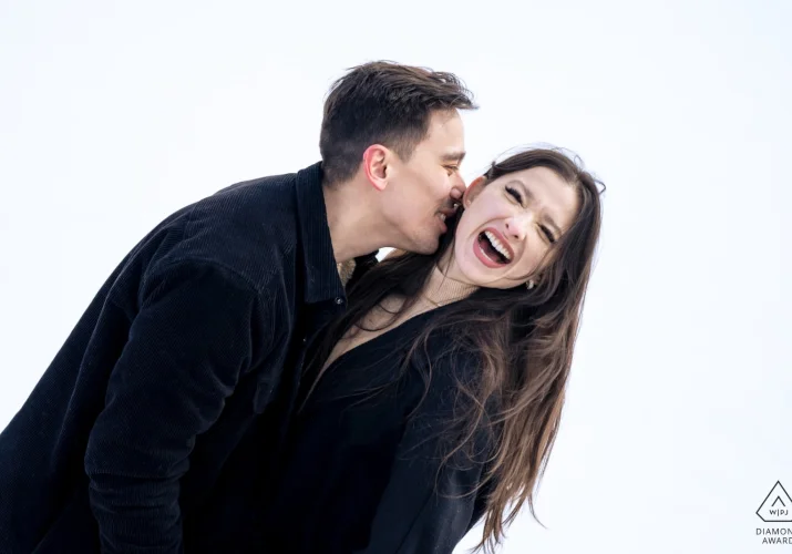 Funny moment of an engaged couple when a man tries to kiss his fiancée's neck.