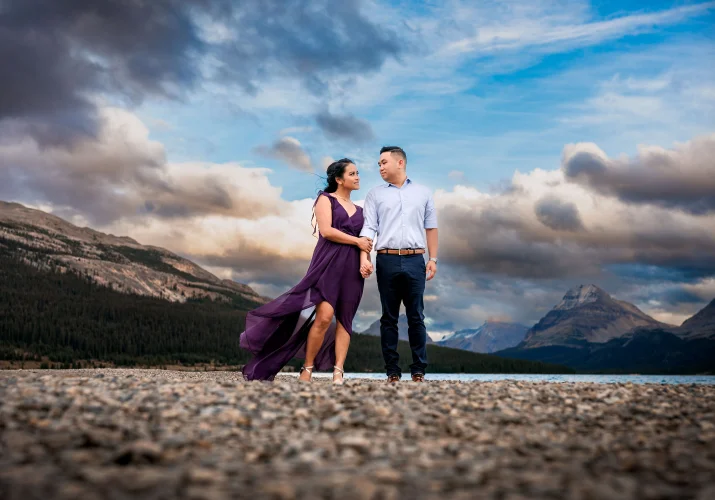 Engaged couple is walking by the ;ale during engagement session in Banff