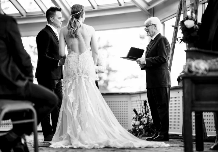 The officiant giving a speech to newly-weeds at the Fairmont Wedding in Banff. Moment captured by Banff Wedding Photographer.