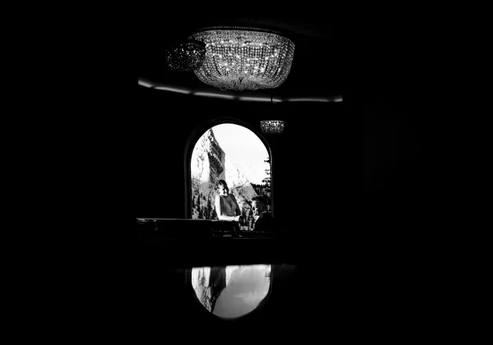 Creative wedding photograph of the groom playing piano for his wife taken by talented Banff wedding photographer.