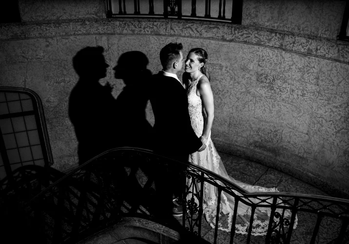 Bride and groom standing on the stairs, facing each other and look deeply into each others eyes during wedding portrait session captured by Banff Wedding Photogarpher.