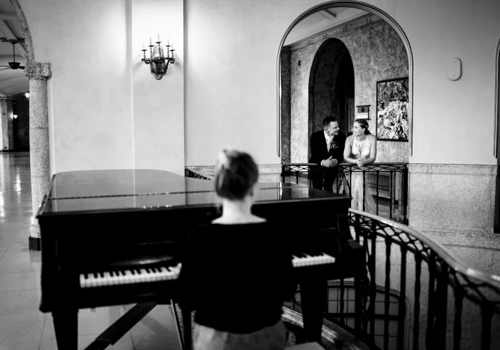Pianist plays for the newlyweds while they are listing and look at each other with love.