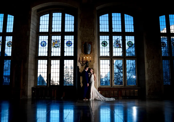 Bride and groom talk nest to the giant and stunning windows at Fairmont Banff Springs.