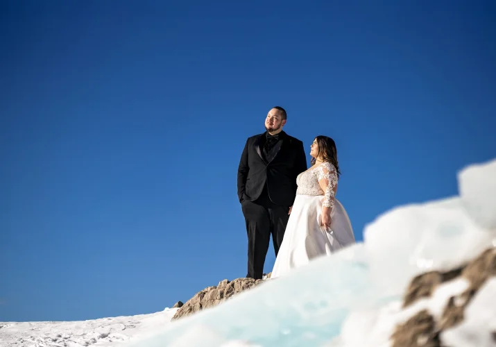 Banff Wedding Photography of the newlyweds standing at the frozen hill.