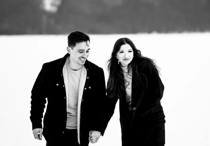 Lifestyle photograph of the young couple walking and holding hands. They look happy.