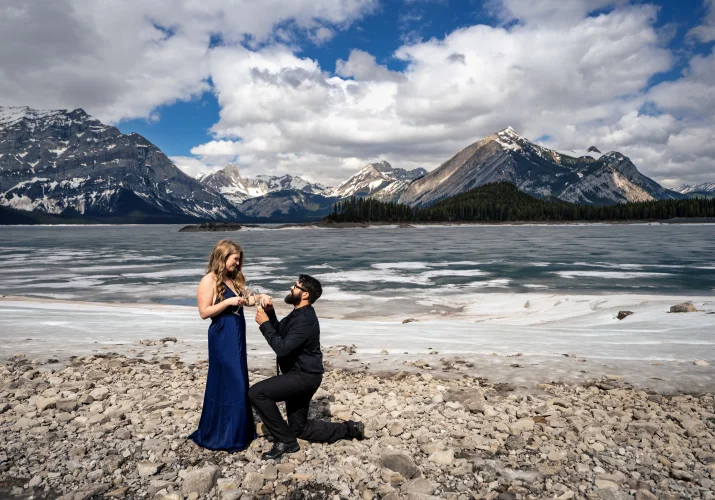 Romantic proposal in Banff. Man goes down the knee with the engagement ring in his hand.
