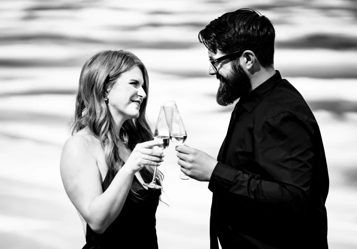 Amazing photograph in black and white of the couple celebrating their love with glasses of champagne.