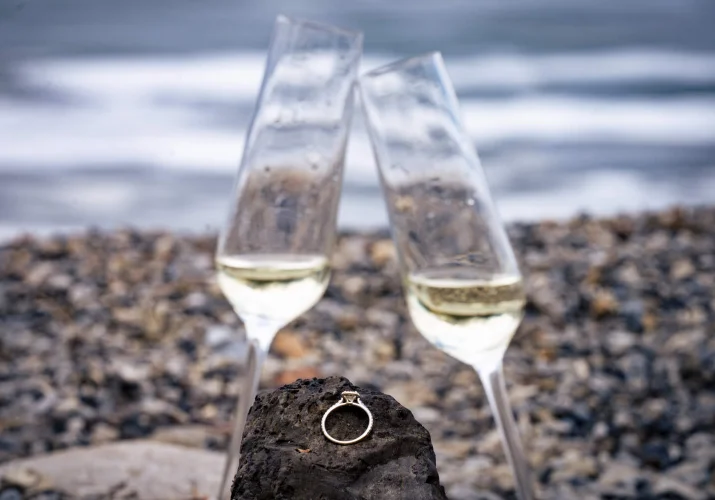 Engagement ring on the rock nest to the glasses on champagne.
