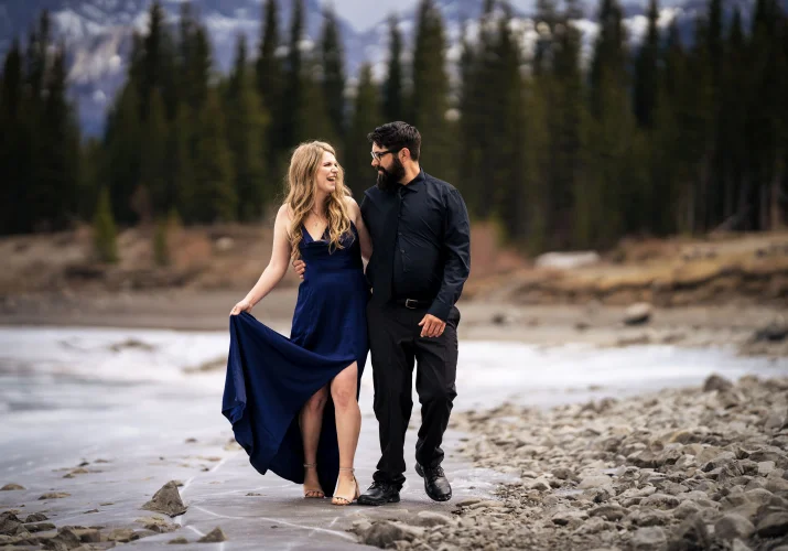 Engaged couple walk down the lake in Banff.