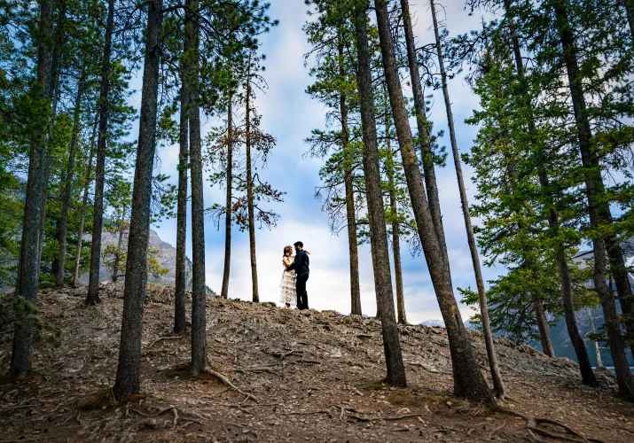 Couple in a hug in the middle of the Banff's forest.