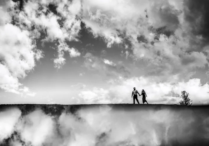 Creative photograph of the couple walking in the clouds.