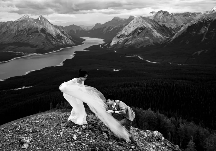 Photograph in black and white on the peak of the mountain when the groom hiked to rescue the brides veil.