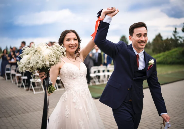 Happy newlyweds with their hands up after the Calgary Wedding Ceremony