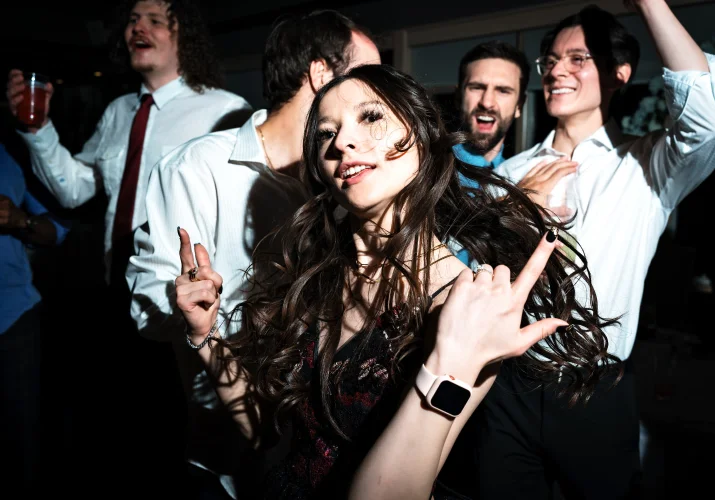 Bride is having fun on the dance floor behind her guests.