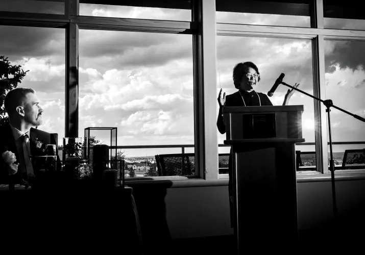 mother of the bride gives a speech during Wedding Reception. behind the window heavy clouds.