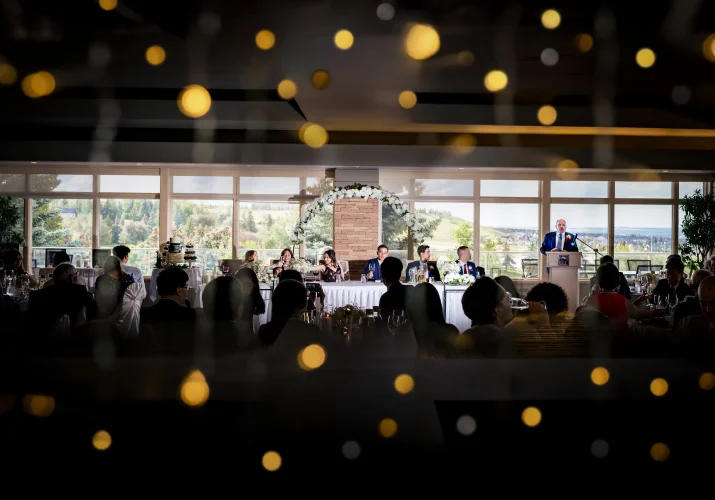 Creative photograph on the wedding table at the wedding reception while the guests raise the glasses,