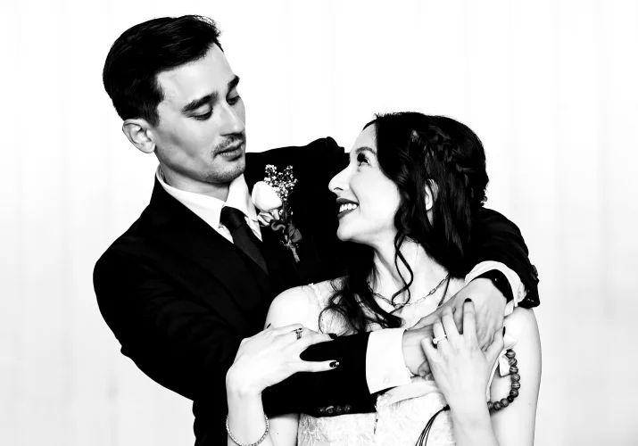 Cute wedding portrait in black and white of the groom and the bride looking at each other.