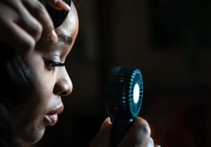 Bride uses a small electric fan during hot Calgary Wedding Day.